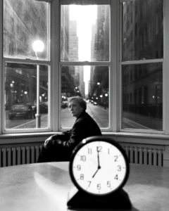 A photograph of a person sitting alone by a window in the middle of the night, reflecting on their life and experiencing an existential crisis and emotional numbness.