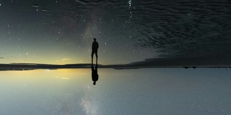 person contemplating cosmic insignificance under a starry night sky