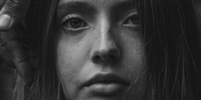A person expressing emotional pain and internal conflict.
