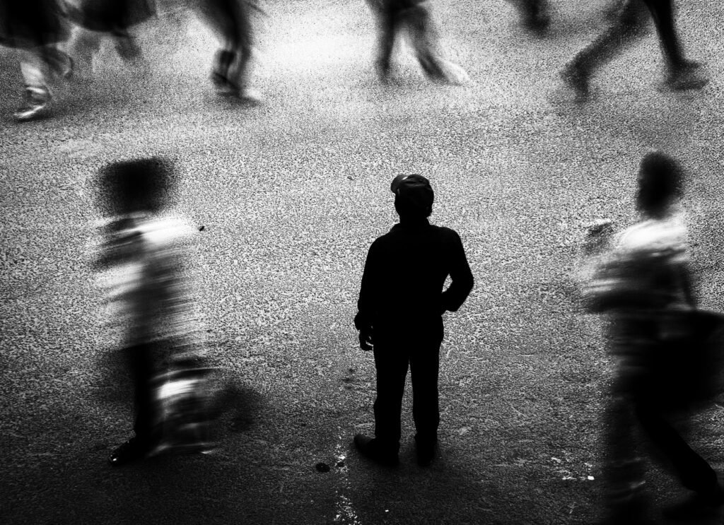 A person feeling lonely and disconnected in a crowded room.