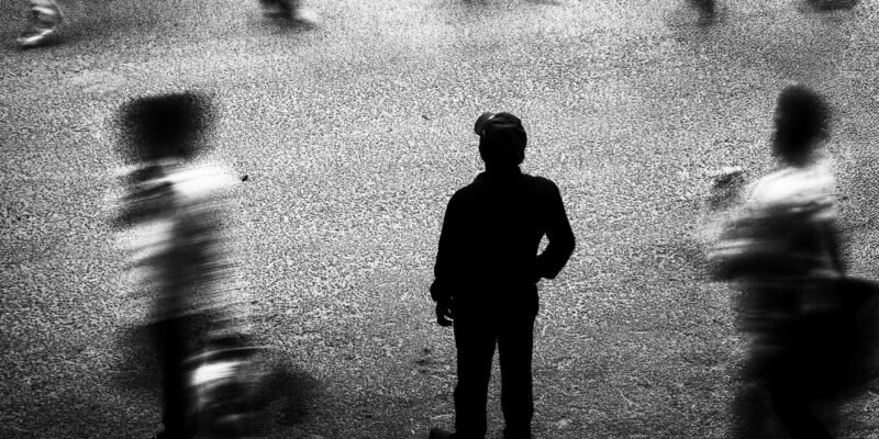 A person feeling lonely and disconnected in a crowded room.