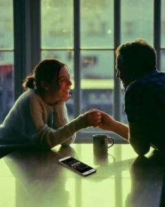 A couple shares a moment of real connection and genuine compliments over coffee with a smartphone face down on the table, illustrating the choice between online vs reality and learning how to stop caring what strangers think online.